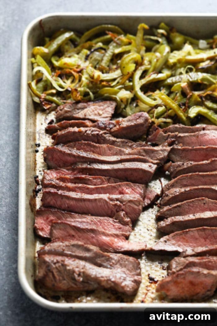 A selection of prepped ingredients for Philly Cheese Steak bowls, including sliced steak, roasted vegetables, and rice.