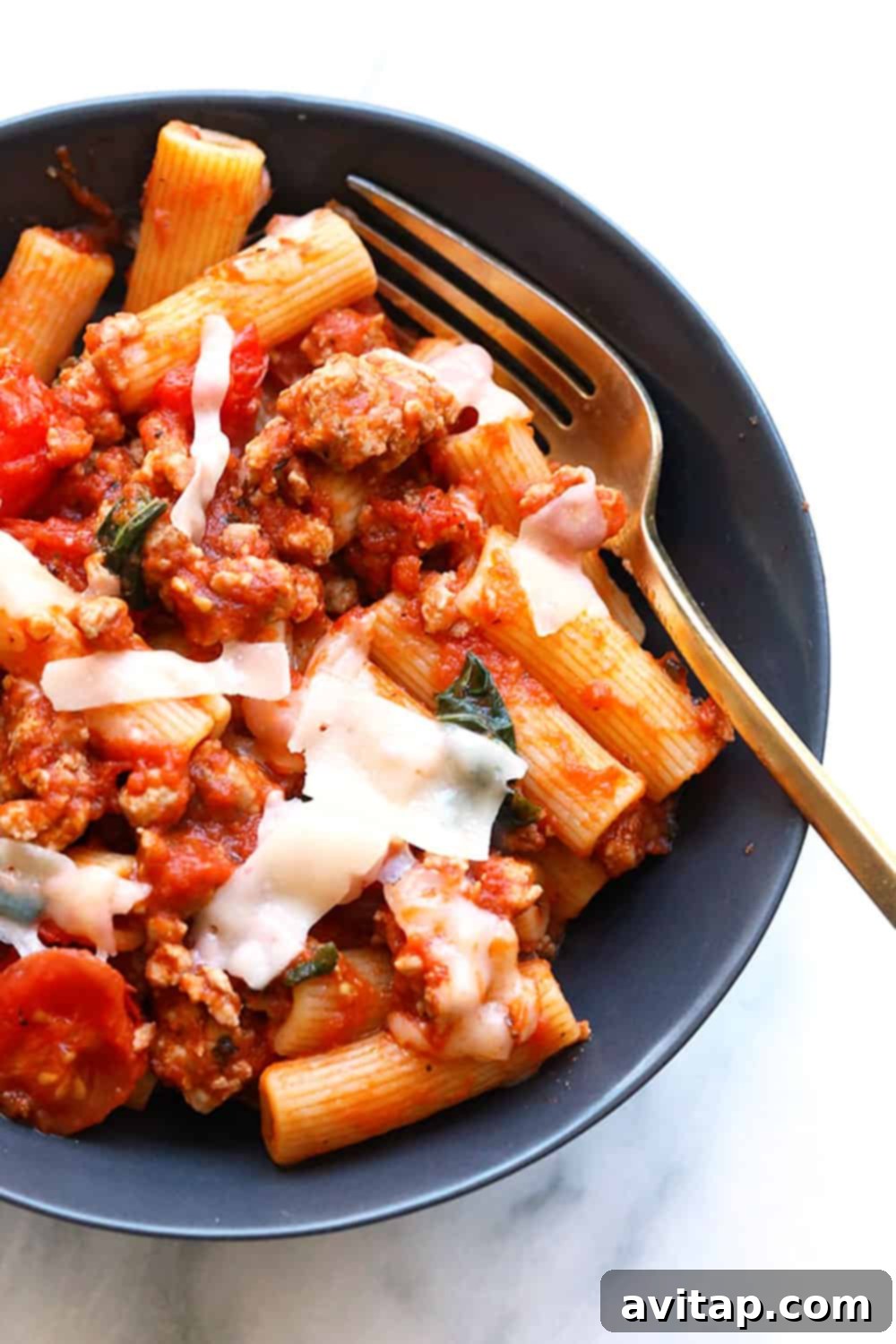 A top-down view of Sausage Pizza Pasta in a bowl, garnished with fresh basil, ready to be enjoyed.