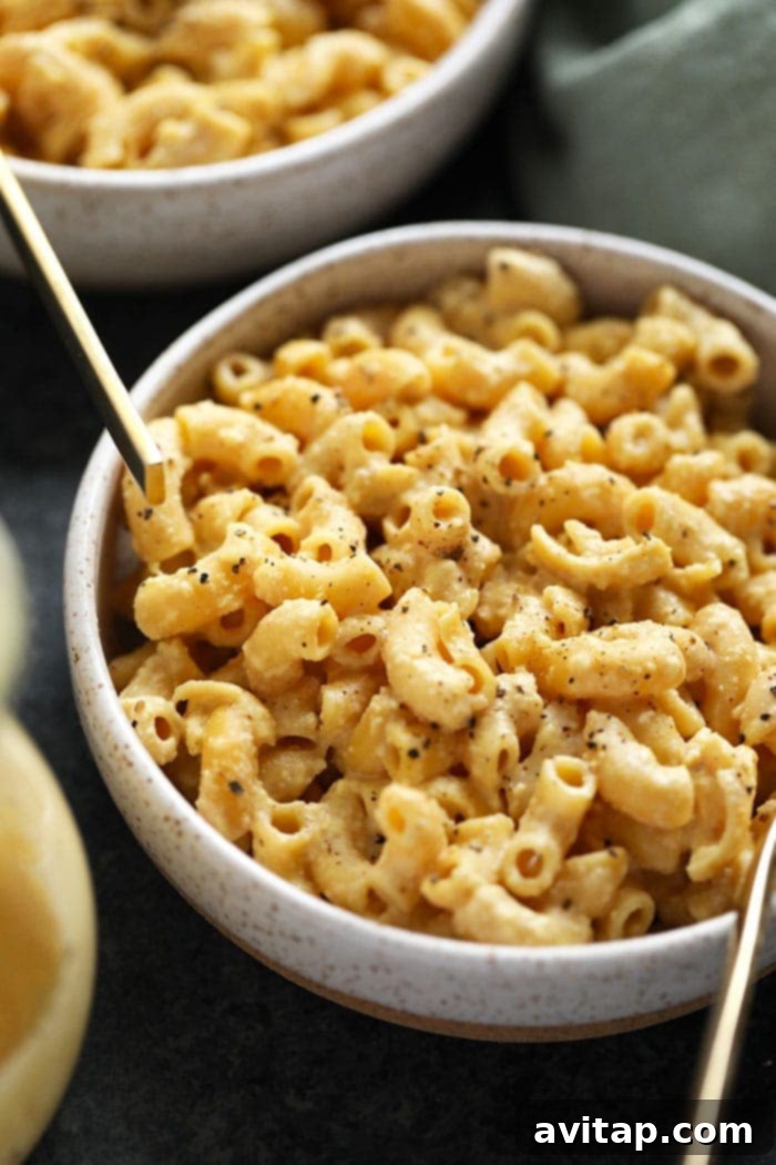 A close-up shot of a single bowl of vegan mac and cheese, highlighting its rich, creamy texture and comforting appeal.
