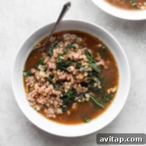 Hearty Kale soup with ground turkey and savory pancetta in a white bowl.