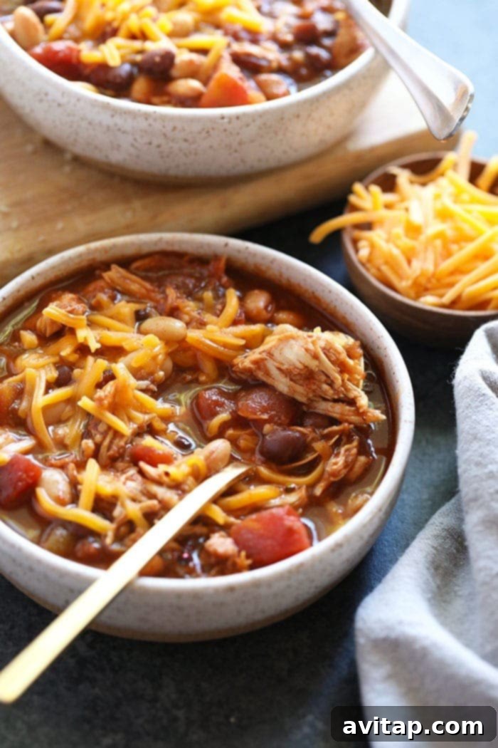 A steaming bowl of Crockpot Chicken Chili, garnished with fresh cilantro and a dollop of sour cream, ready to be enjoyed.