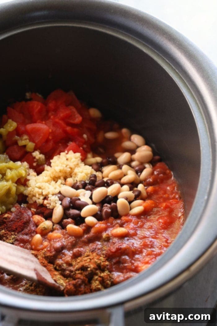 Ingredients for chicken chili simmering in a crockpot, showcasing the rich colors and textures.