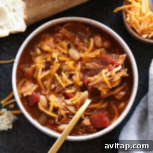 Chicken Chili in a bowl, topped with fresh avocado and cilantro.