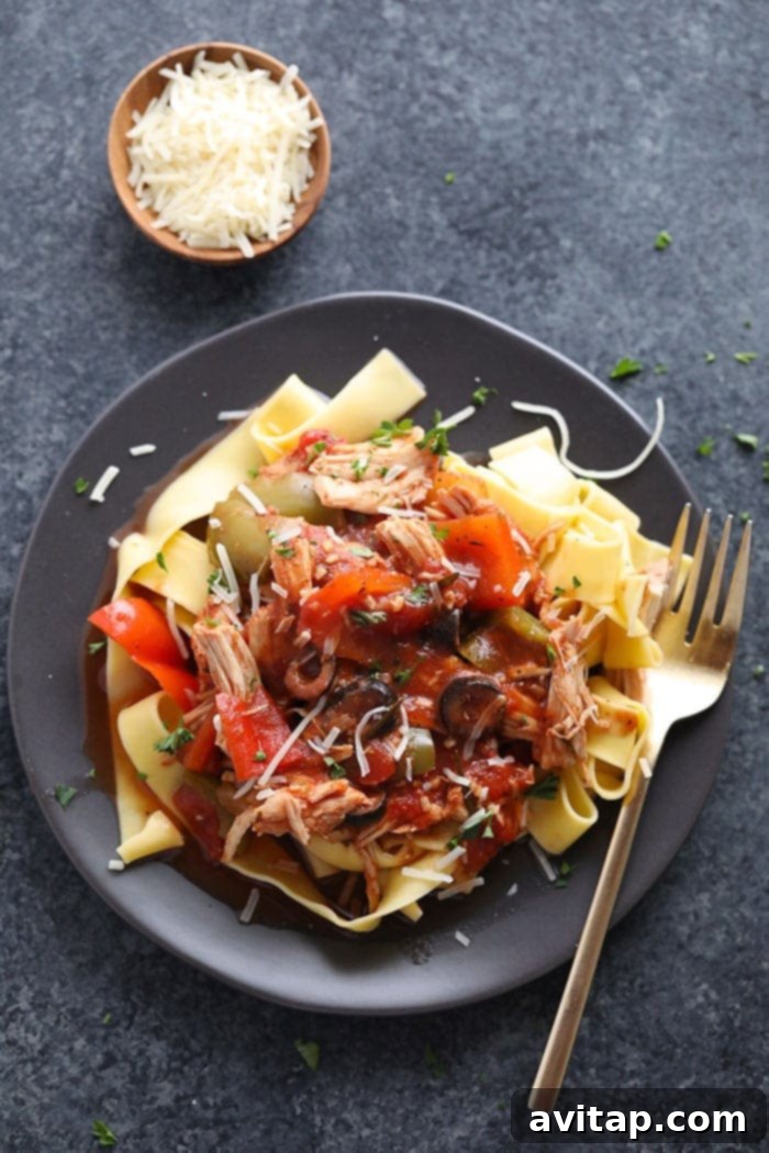 Close-up of shredded chicken cacciatore in a slow cooker, highlighting the tender, fall-apart chicken and savory tomato sauce.