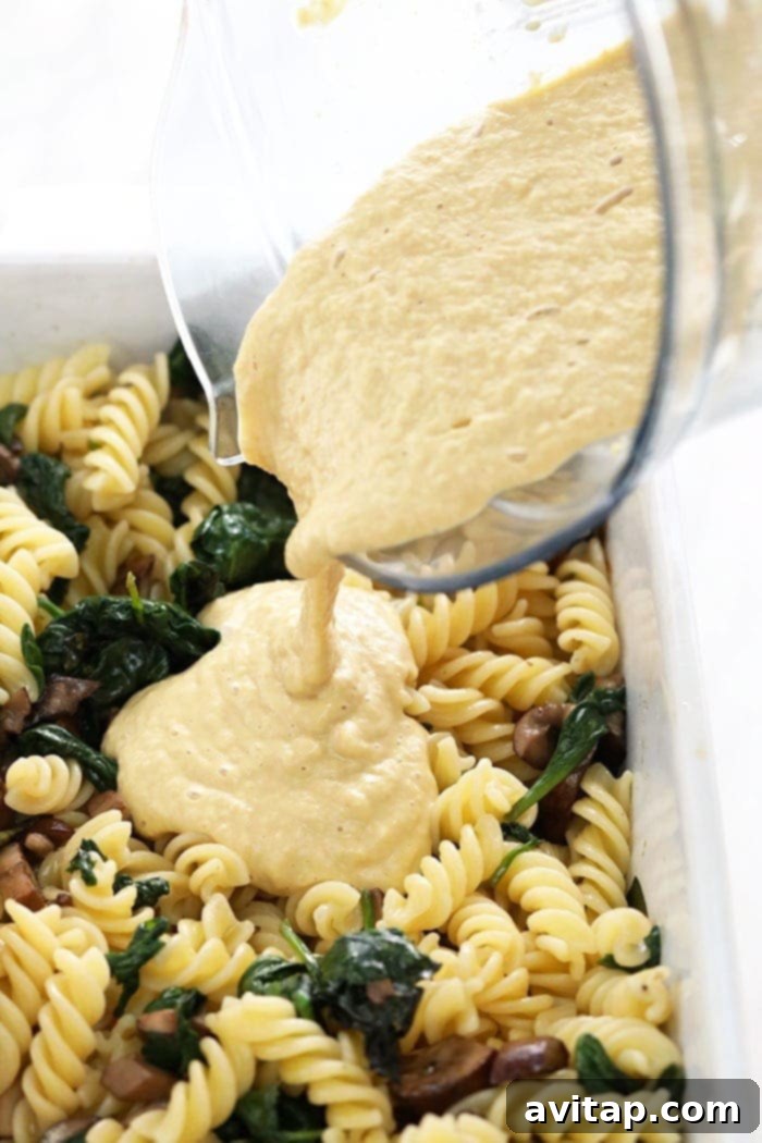 Rich vegan pasta bake with white wine cashew sauce in a ceramic casserole dish, ready for serving.