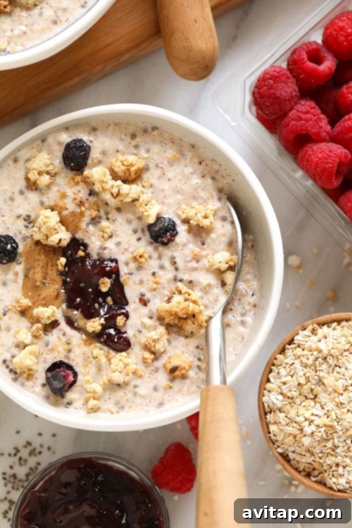 A bowl of creamy overnight steel cut oats topped with fresh berries and a drizzle of nut butter, ready to eat.