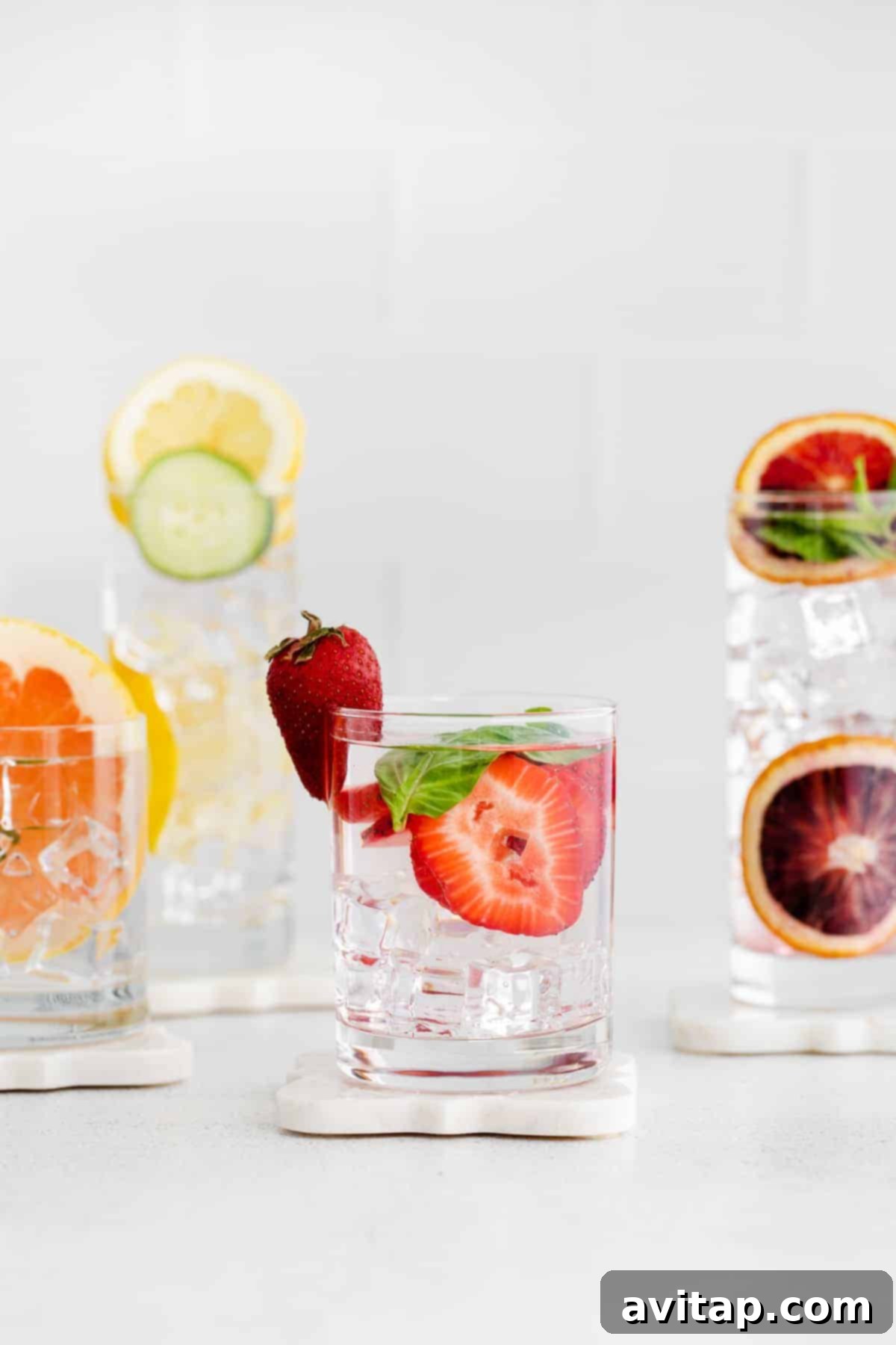 Assortment of vibrant fruit infused water glasses, showcasing various fruit and herb combinations.