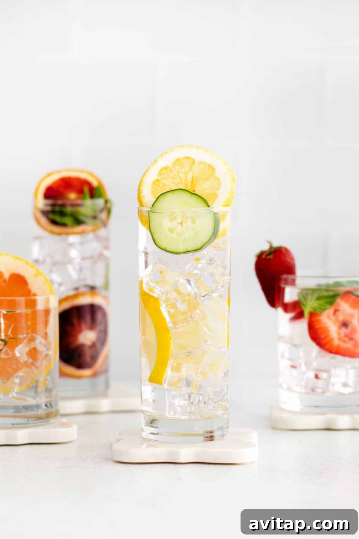 Variety of fruit infused water drinks in glasses, ready to be enjoyed.