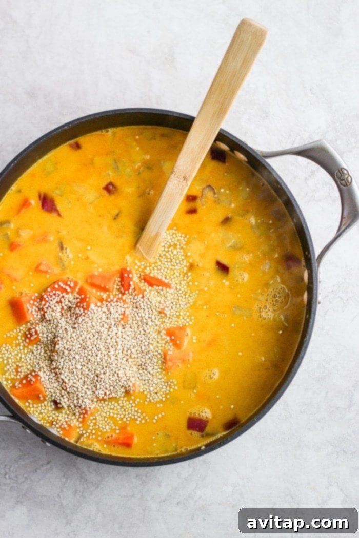 A bowl of steaming curry chicken soup with fresh herbs.