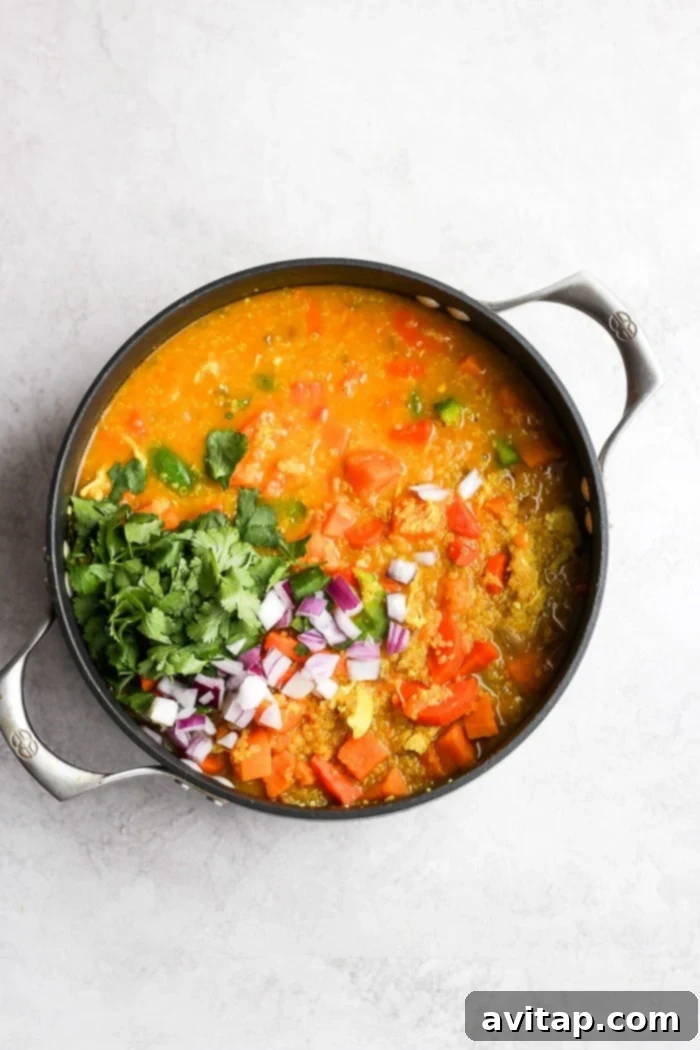 A bowl of Golden Chicken Curry Soup garnished with fresh cilantro.