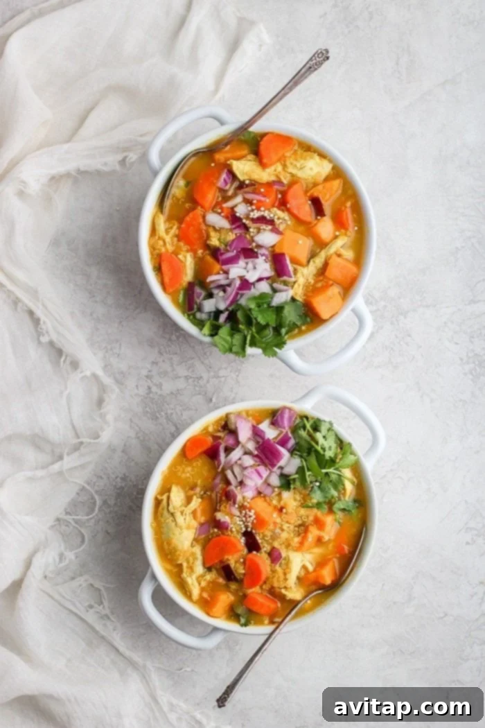 A large pot of golden chicken curry soup simmering on the stove.