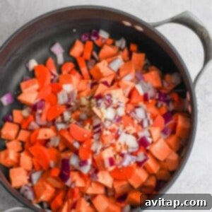 Cooked carrots and onions in a pan for curry chicken soup.