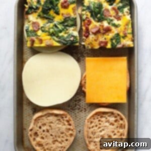 Process of assembling breakfast sandwiches on a baking sheet.