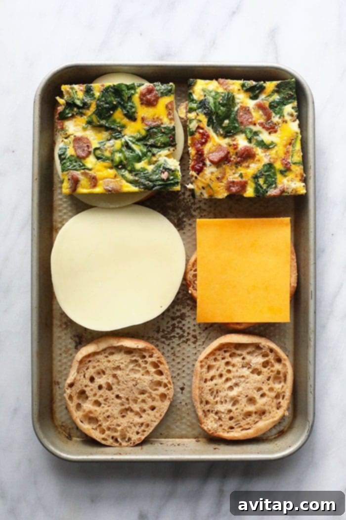 Assembling make-ahead freezer breakfast sandwiches on a sheet pan.
