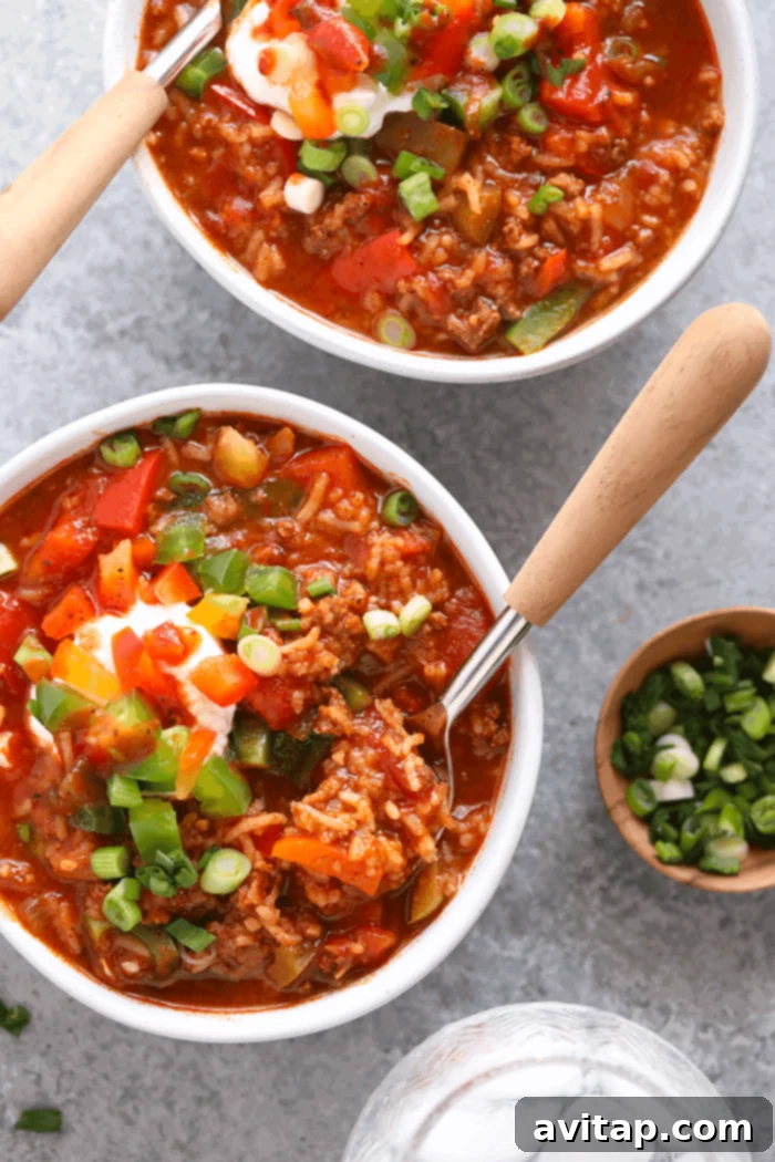 Enjoy a hearty bowl of Instant Pot Stuffed Pepper Soup – quick, easy, and satisfying! A vibrant bowl of Instant Pot Stuffed Pepper Soup, topped with fresh green onions and cheese, ready to eat with a spoon.