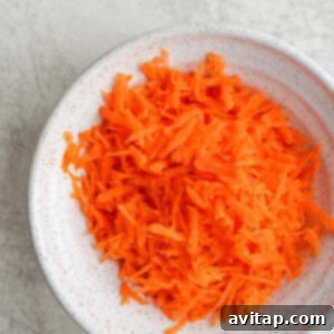 shredded carrots in a white bowl.