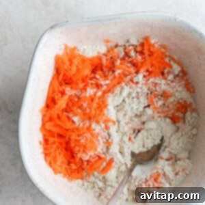 a white bowl with carrots and flour in it.