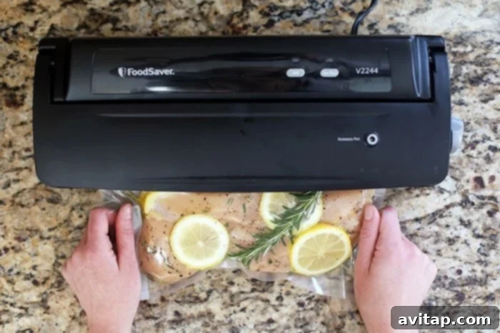 Vacuum sealed chicken breast in a food saver bag with herbs and lemon.