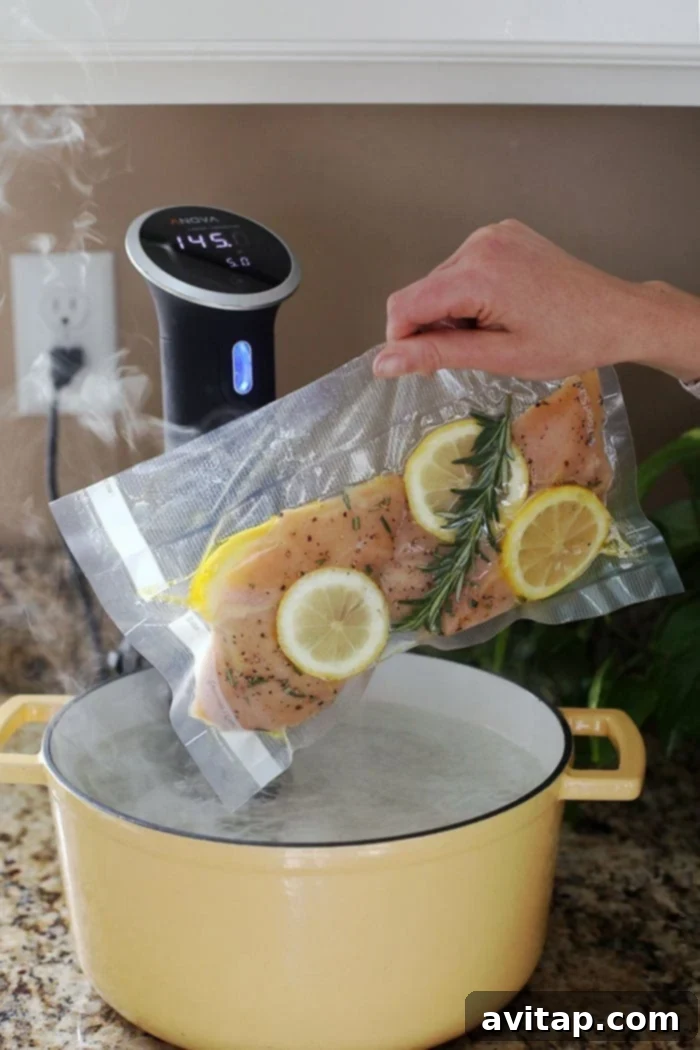 Sous vide chicken breast submerged in a water bath.