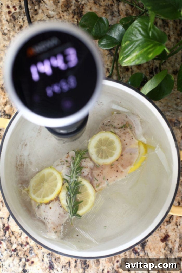 Sous vide chicken breast cooking in a pot of water, ready to be removed.