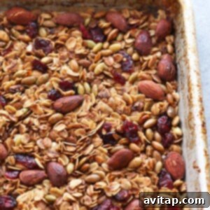 Effortless Granola Bliss 4 Healthy granola with nuts and cranberries in a baking pan, just out of the oven.