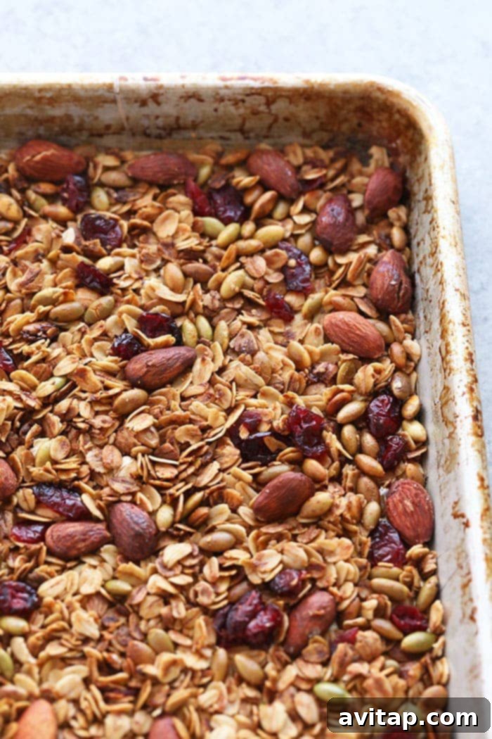 Golden-Brown Homemade Granola Baking Sheet Freshly baked granola spread on a baking sheet, cooling to a perfect crisp.