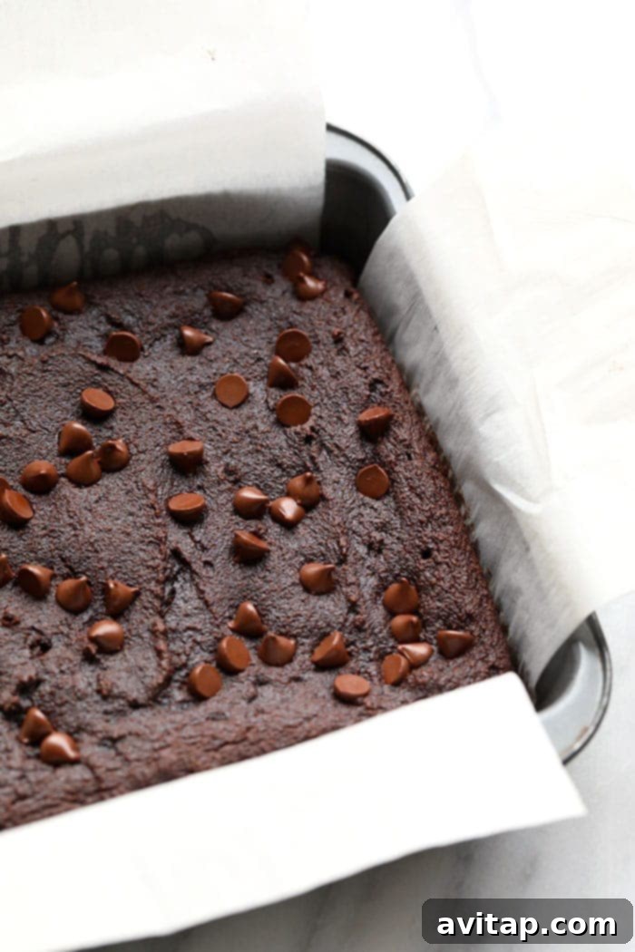 Freshly baked healthy beet brownies, cooled and ready for slicing. Baked healthy beet brownies cooling in a square pan, ready to be cut.
