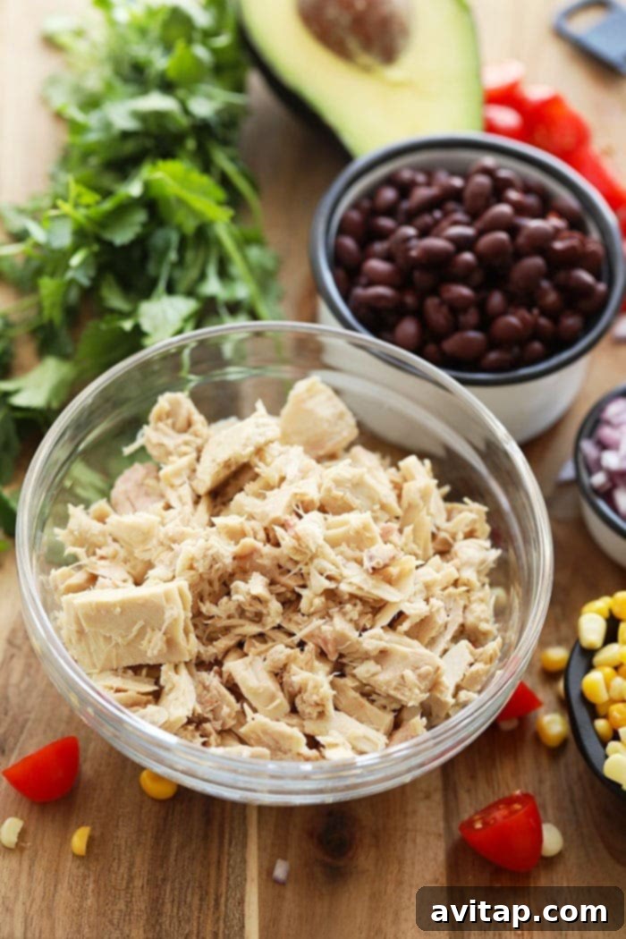 Close-up of a healthy tuna salad without mayo, showing colorful ingredients like black beans, corn, and cherry tomatoes, tossed in a light dressing.