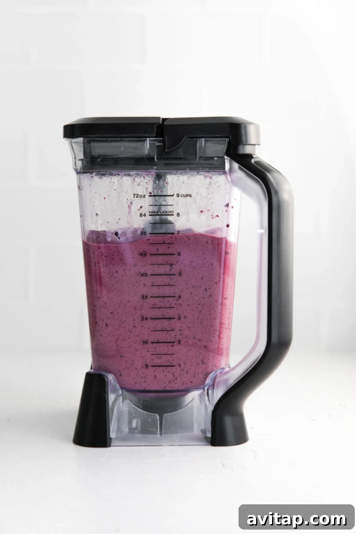 A perfectly blended triple berry protein smoothie swirling in a high-speed blender.