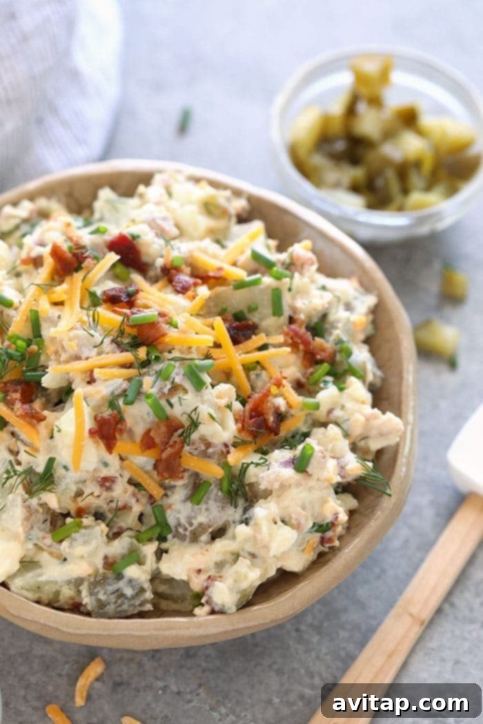 A close-up shot of loaded baked potato salad in a serving bowl, ready to be enjoyed.