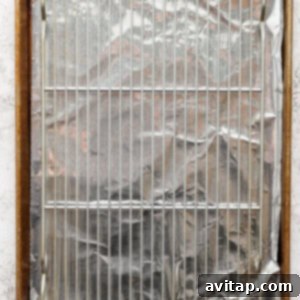 A baking sheet lined with aluminum foil, with a metal wire rack placed on top.
