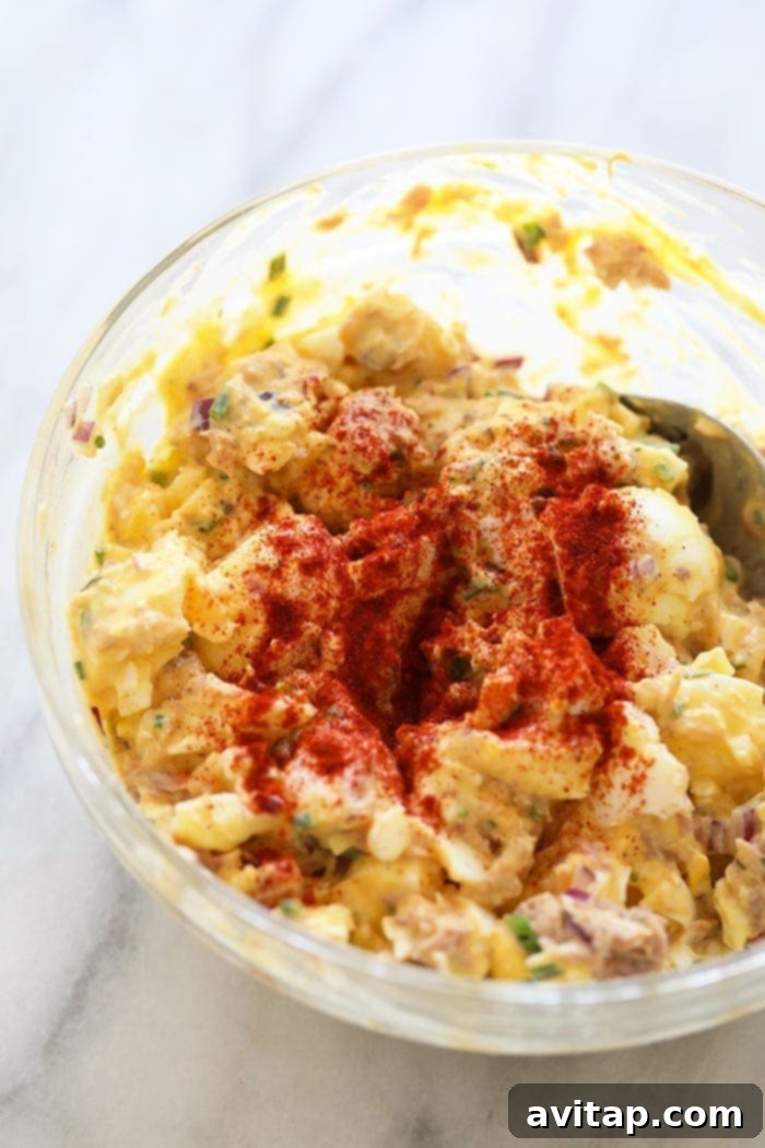 Tuna Salad with egg takes classic tuna salad up a natch by adding in hard-boiled eggs. This tuna salad recipe with egg whips up in no time and it's healthy! Finished tuna egg salad mixed in a large glass bowl