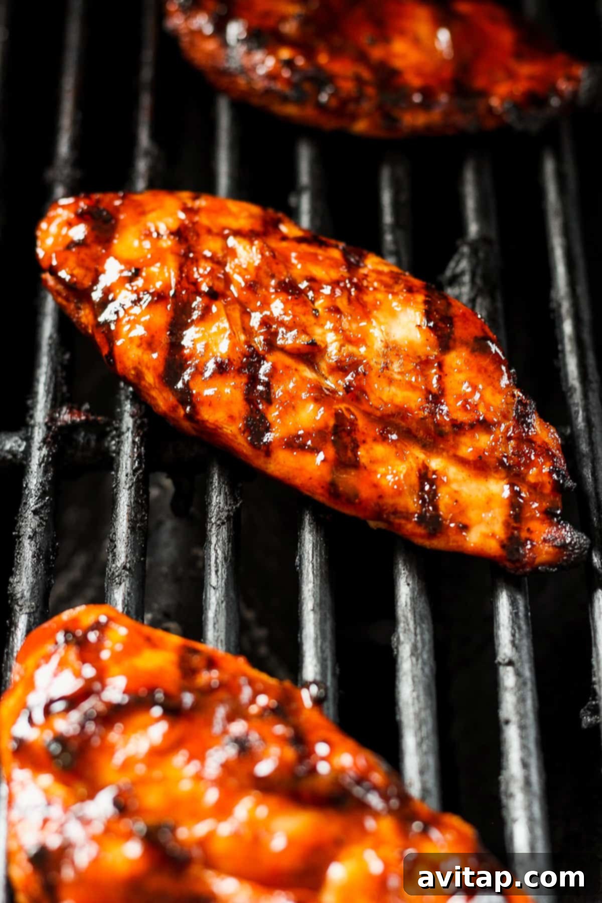 Smoky BBQ Chicken Perfection 5 Four pieces of grilled chicken breast on a cutting board, ready to be sliced.