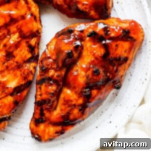 bbq chicken breasts on a white plate.