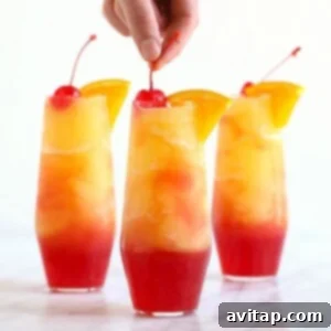 Close-up of Sex on the Beach Slushies in elegant glasses, garnished with orange slices and maraschino cherries.
