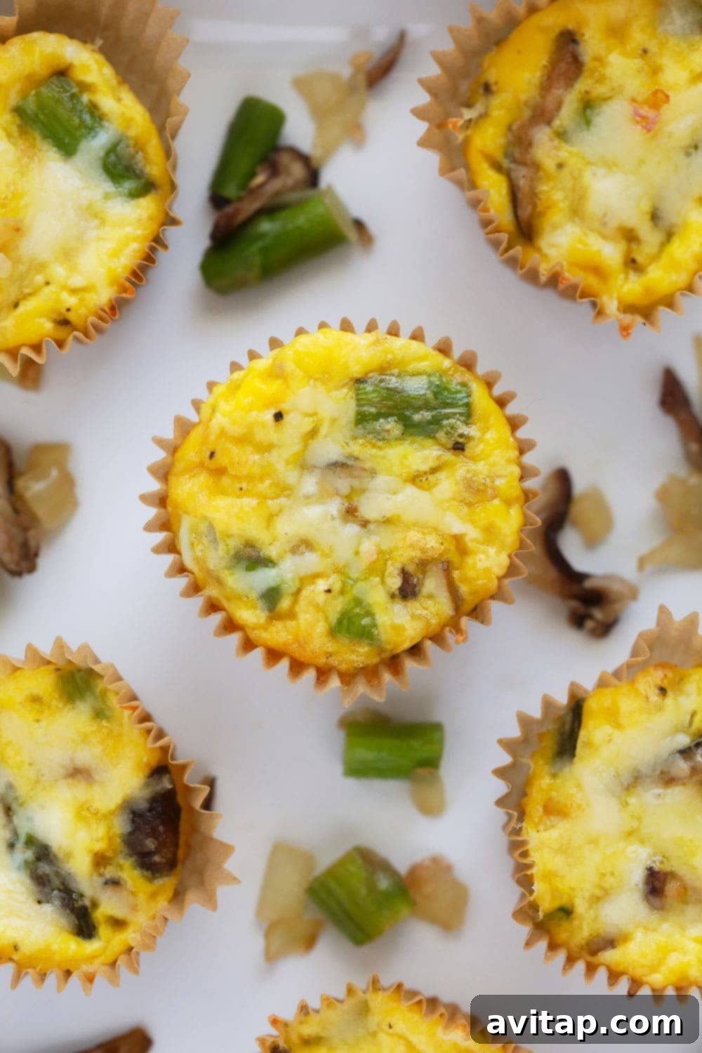 A delicious asparagus and mushroom egg cup, packed with 4 grams of protein and quick to prepare. Close-up view of a single asparagus and mushroom egg cup, showcasing the vibrant ingredients within.