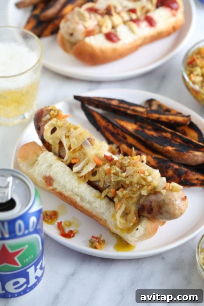 A perfectly cooked beer brat nestled in a bun with classic toppings like ketchup, mustard, and relish, ready to be enjoyed.