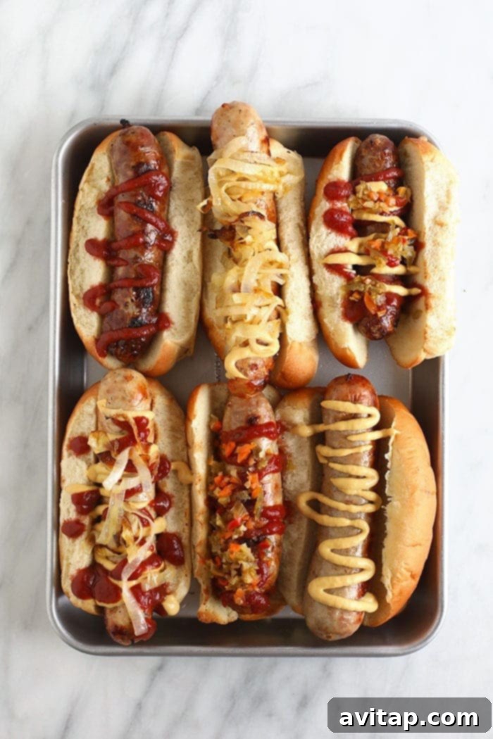 Rows of uncooked brats neatly arranged on a baking sheet, ready for their beer bath, showcasing their natural casing.