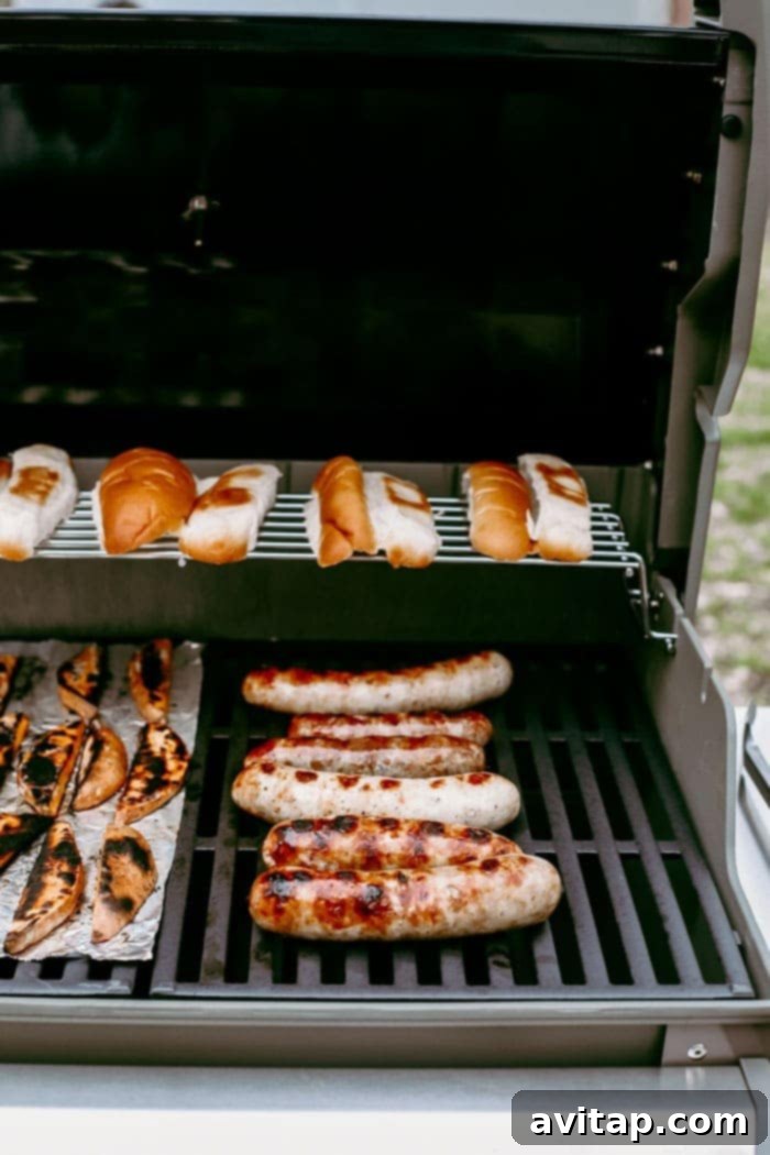 Freshly grilled brats and toasted buns laid out on a grill, ready for assembly and toppings.