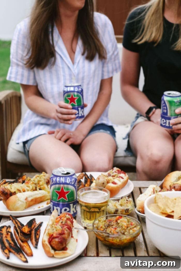Two people enjoying their beer brats outdoors, accompanied by cold drinks, embodying the casual, delicious vibe of a backyard barbecue.