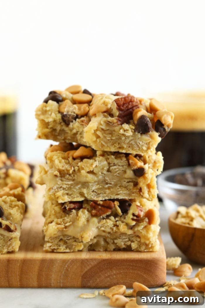 Three healthy Carmelita bars stacked on a rustic cutting board