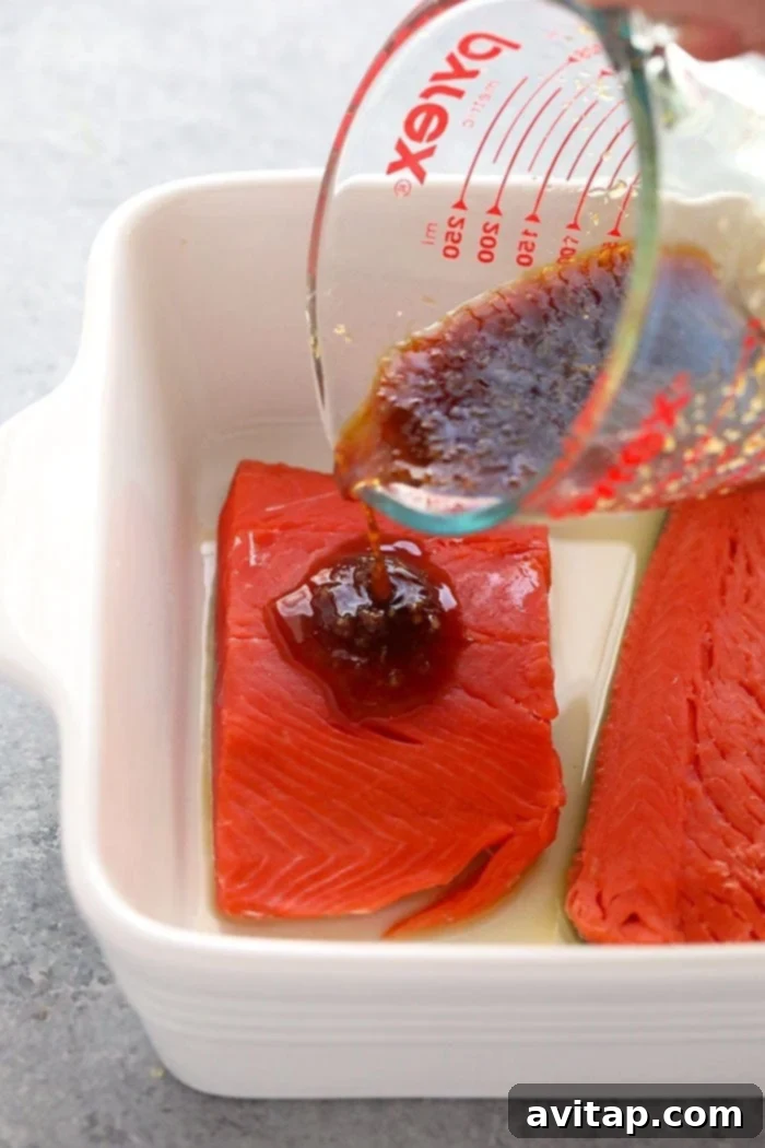 Close-up of the maple ginger sauce being whisked in a bowl, showing its rich, glossy texture before being poured over salmon.