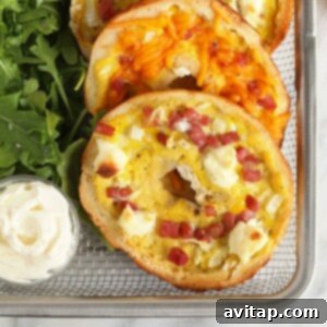 A tray of golden bagel quiches with melted cheese and ham, ready to be served.