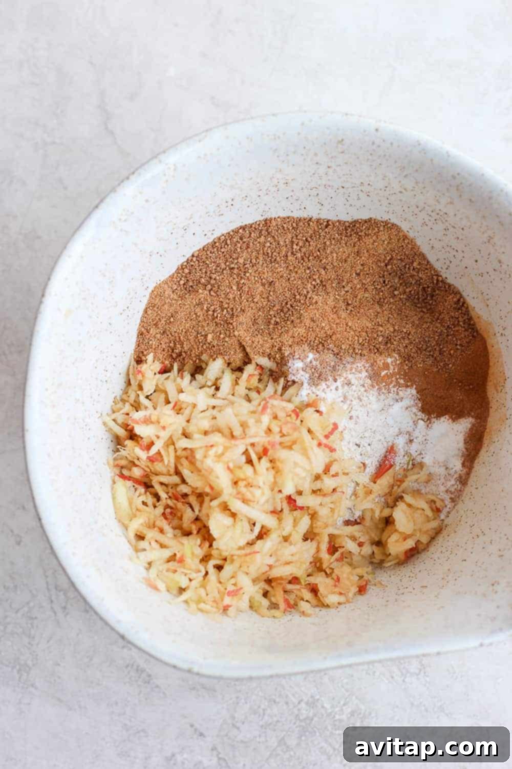 ingredients for healthy apple cinnamon muffins in a mixing bowl