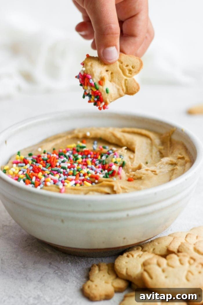 Dipping an animal cracker into colorful funfetti cake batter dip