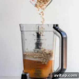 Adding ingredients into the blender for oat milk.