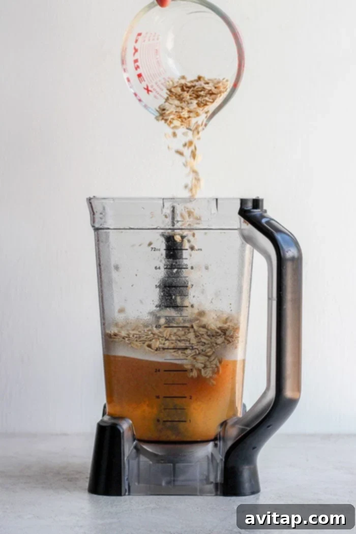 Pouring oats into a blender for oat milk