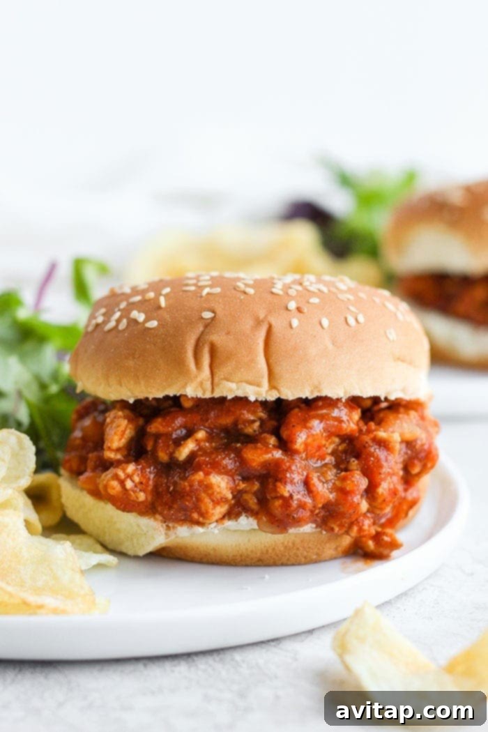 The perfectly savory and sweet Healthy Sloppy Joe Recipe is here! Made with ground chicken and a flavorful sauce packed with clean ingredients, these Sloppy Joes will not disappoint! Healthy sloppy joe on a bun, a close-up of the delicious filling