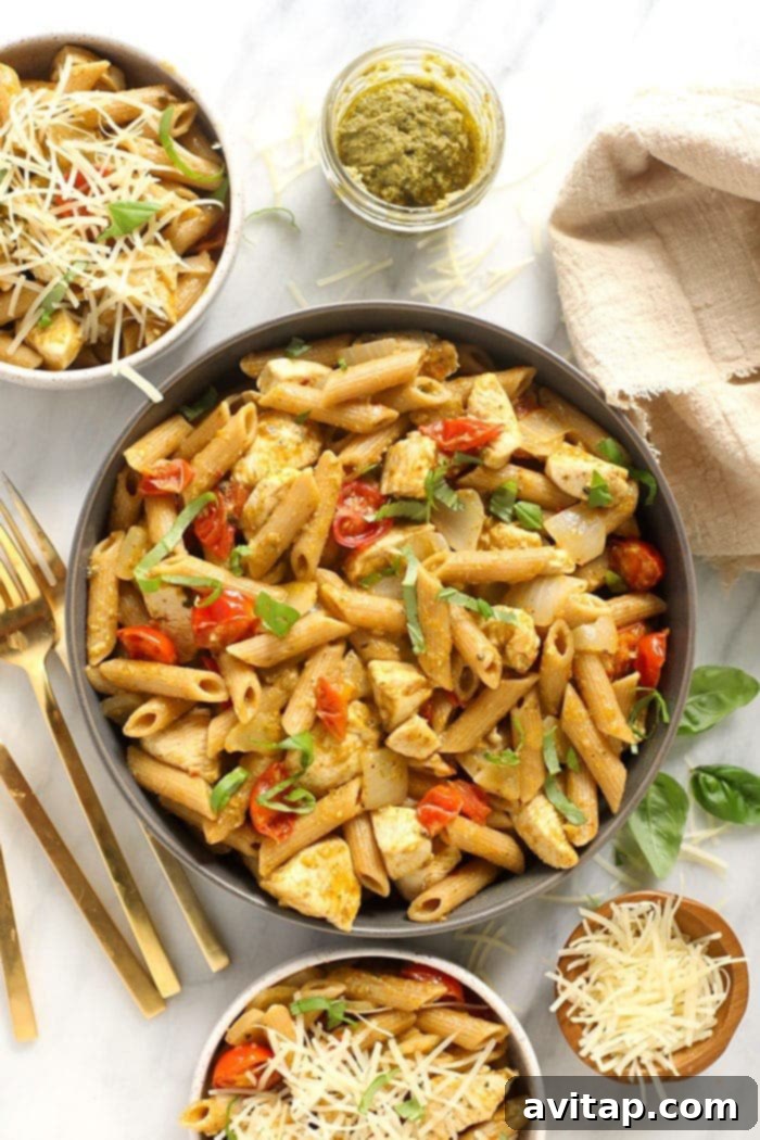 A vibrant bowl of chicken pesto pasta, garnished with fresh basil, ready to be enjoyed for dinner.