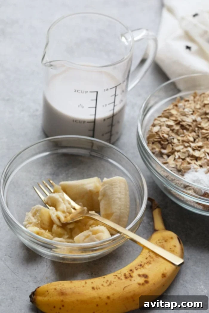 Key Wet Ingredients: Mashed Banana and Almond Milk Close-up of mashed banana and almond milk, key wet ingredients for banana oatmeal bars.